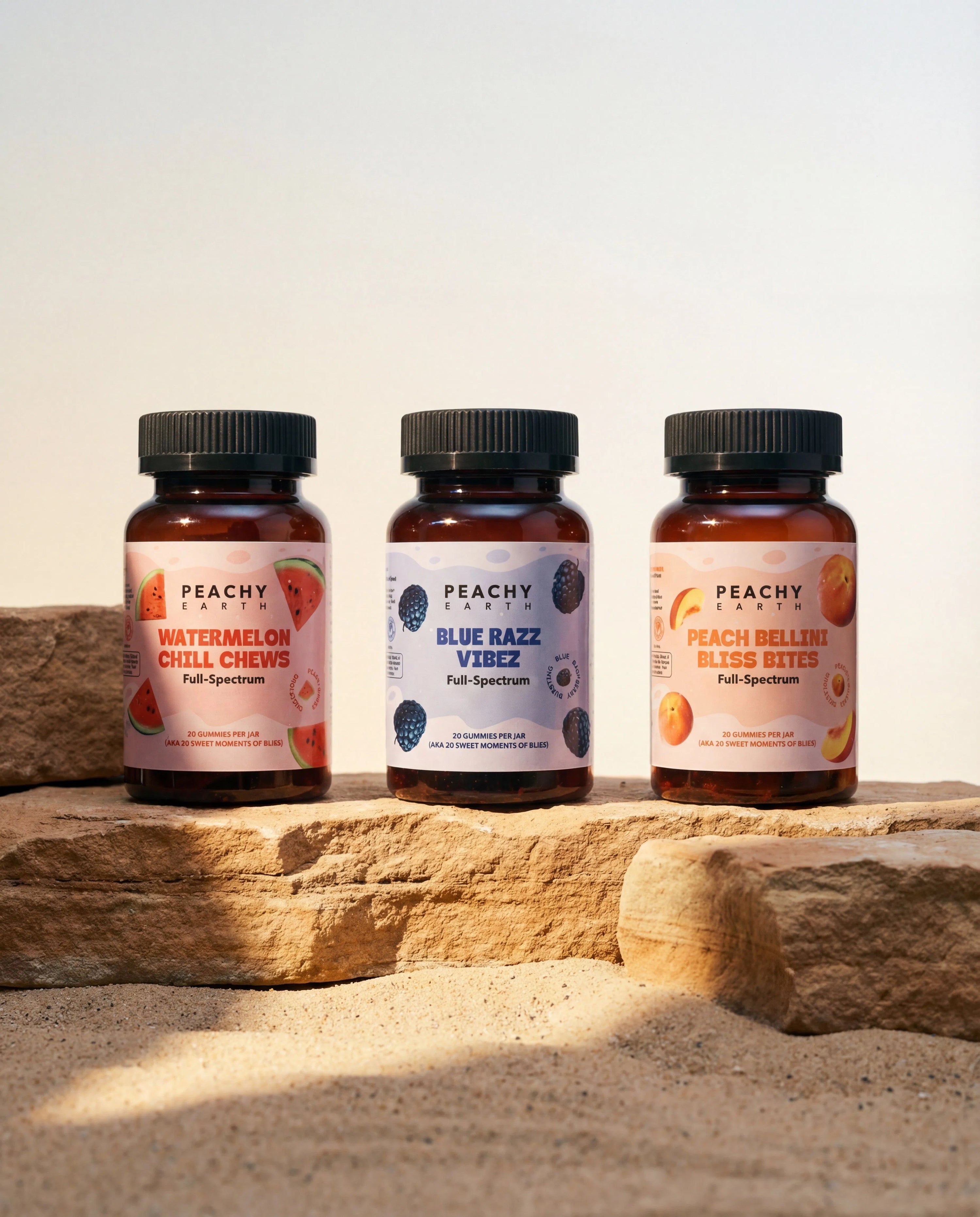 Peachy Earth hemp gummies in three flavors arranged on natural stone
