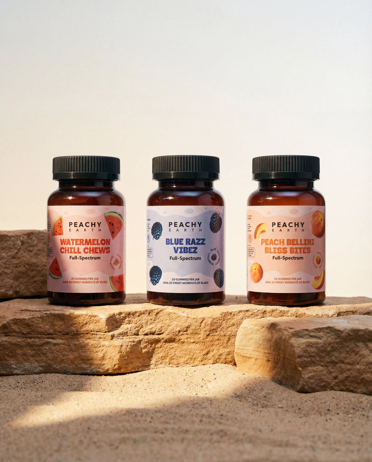 Peachy Earth hemp gummy lineup arranged on natural sand and stone