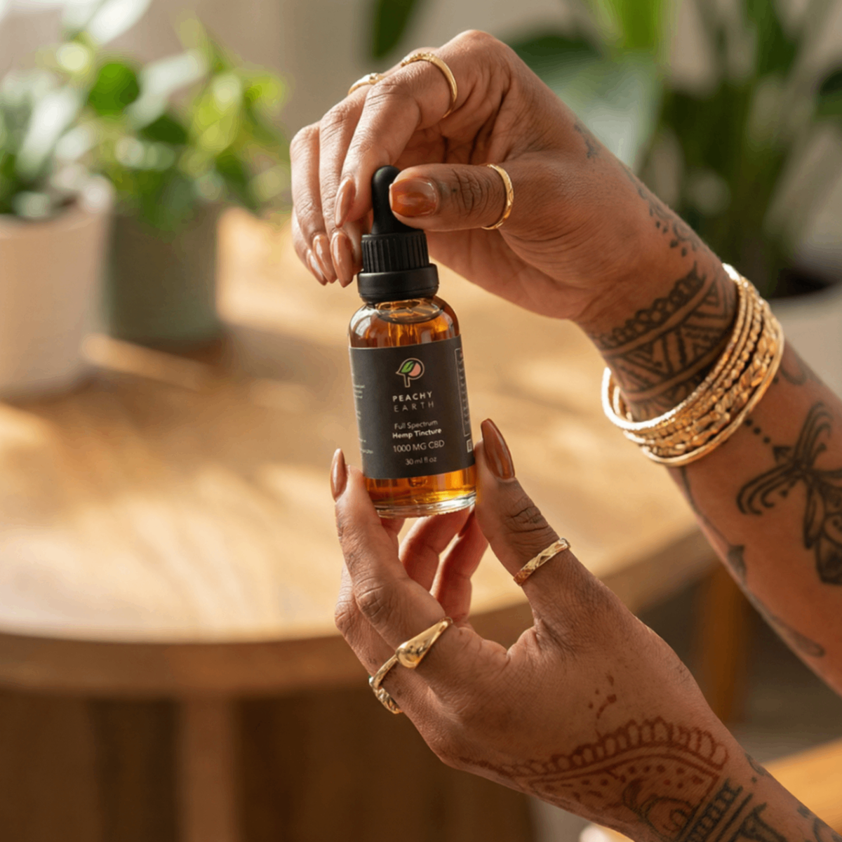 A hand holding a full-spectrum hemp tincture in a warm, sunlit setting