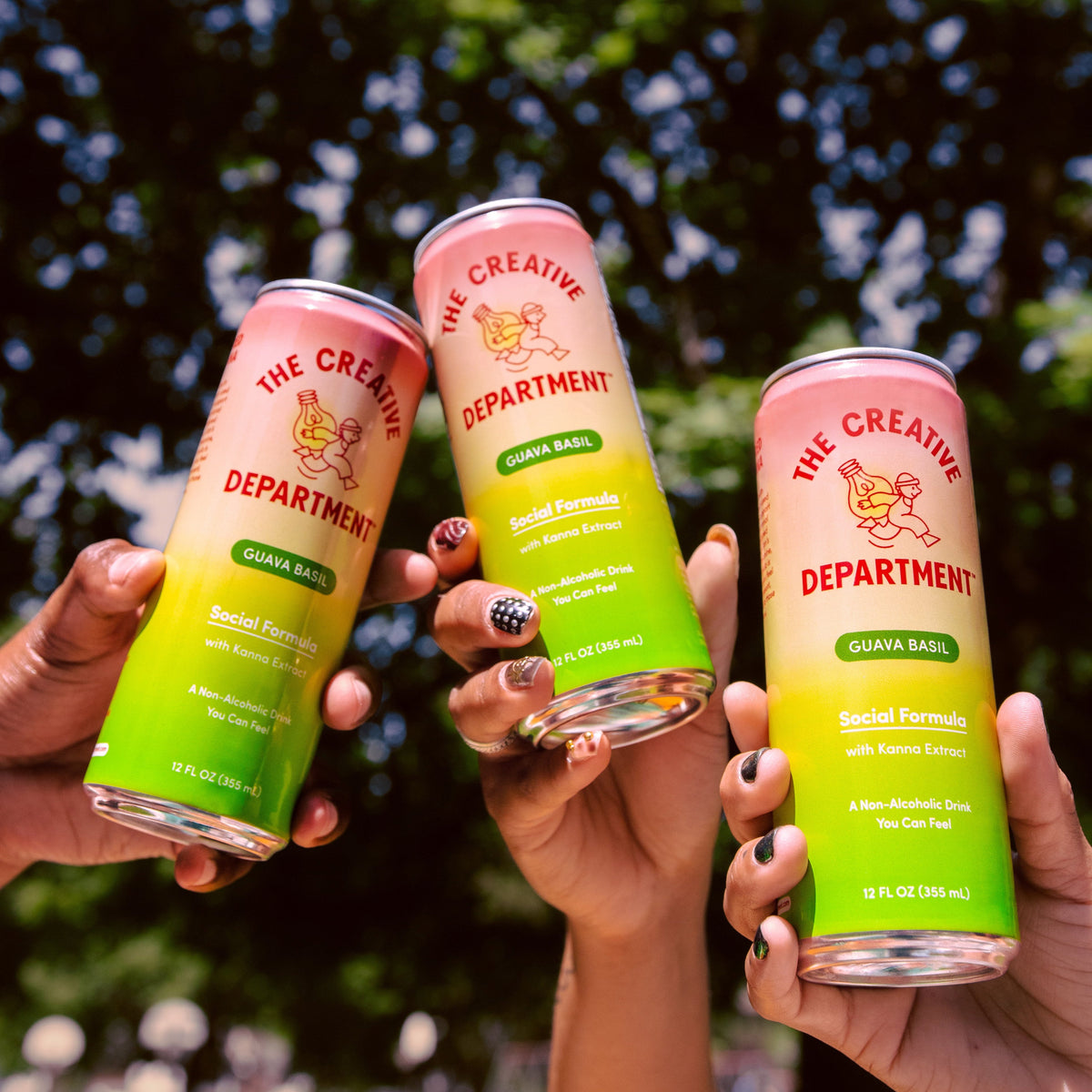 Three cans of Social Formula raised in a toast